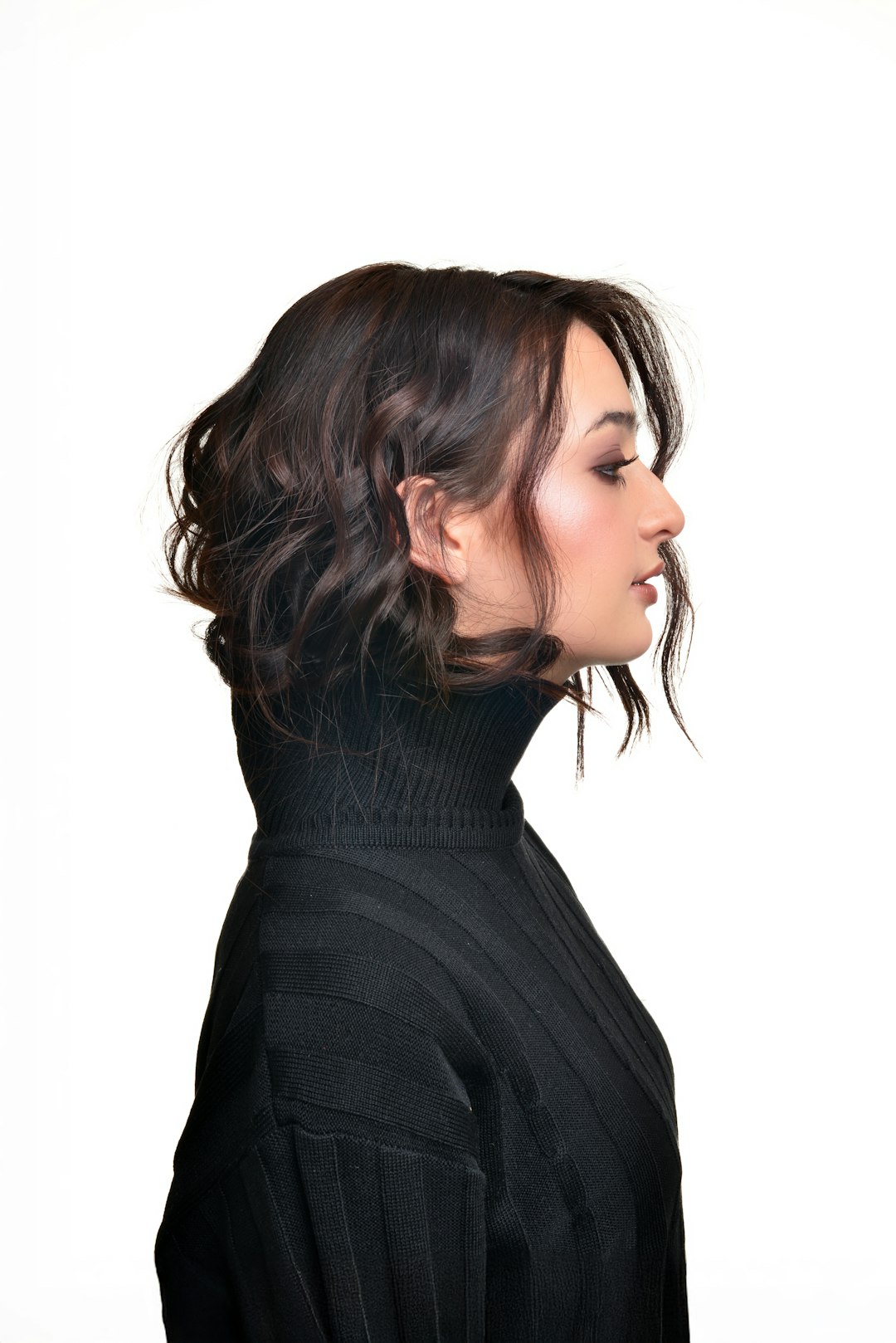 woman with dark wavy hair wearing a black turtleneck portrait cutout transparent background social media profile hair detail