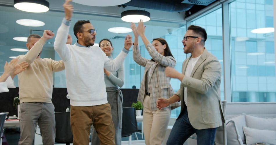 a diverse group of colleagues celebrating success in an office sales contest team energy office fun trophies 1