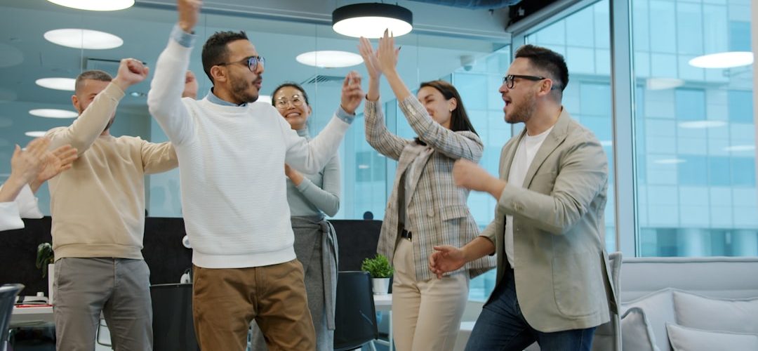 a diverse group of colleagues celebrating success in an office sales contest team energy office fun trophies 2