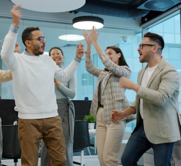 New Product Launch: How Sales and Marketing Teams Can Build Pipeline Before a New B2B Product Goes Live 8 a diverse group of colleagues celebrating success in an office sales contest team energy office fun trophies 2