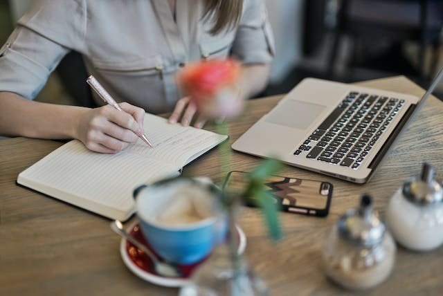 Remember that you are writing for your users at the end of the day. Person writing in their notebook.