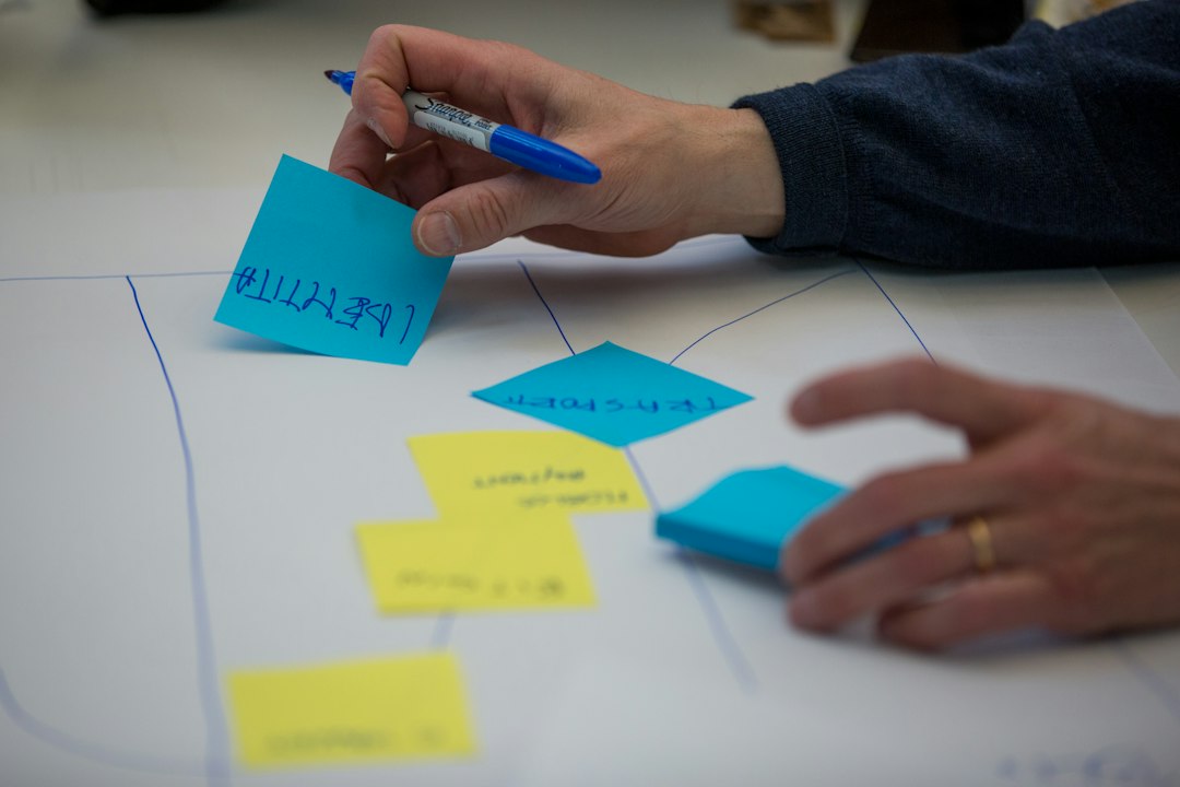 person holding blue pen writing on white paper marketing automation workflow customer journey campaign triggers