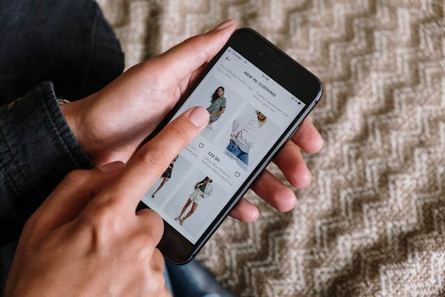 A person clicking on an item to purchase on their smartphone.