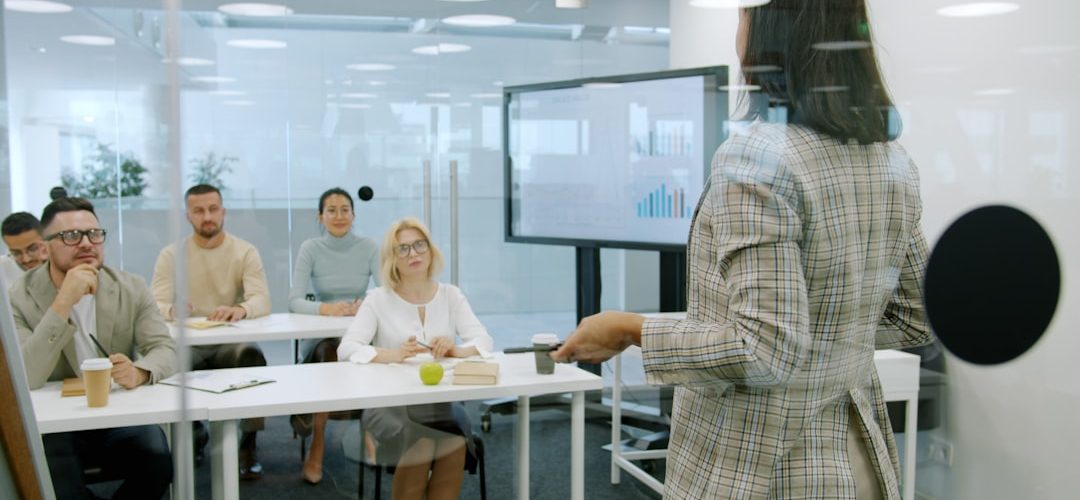 woman presenting to an attentive audience in a modern office online video training business presentation team learning