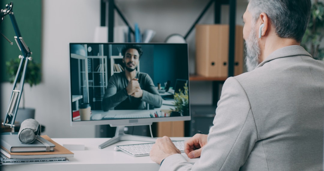 a man sitting at a desk in front of a computer asynchronous communication screen recording remote training