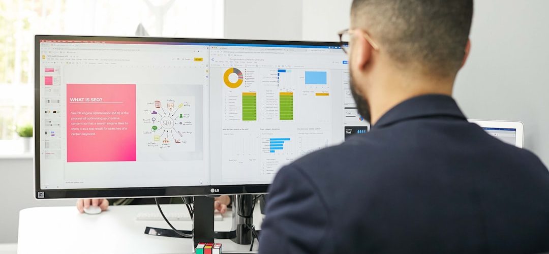 a man sitting at a desk looking at a computer screen project dashboard task management remote workflow
