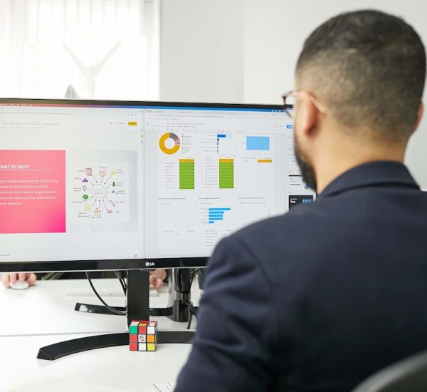 Magos AI Review: Features, Benefits, and Real-World Applications 2 a man sitting at a desk looking at a computer screen project dashboard task management remote workflow