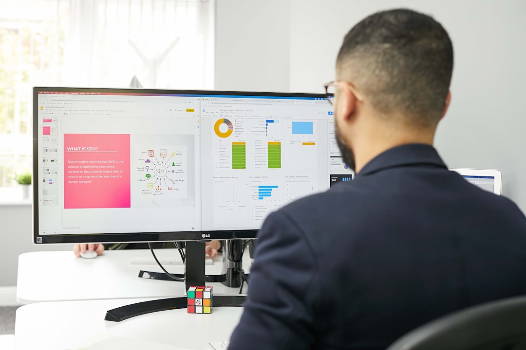 a man sitting at a desk looking at a computer screen project dashboard task management remote workflow
