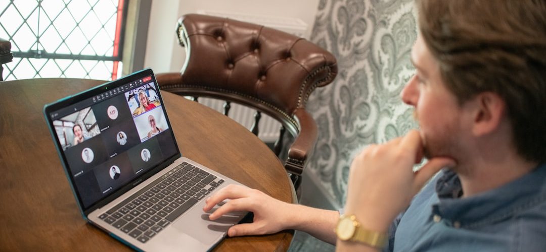 man on laptop participating in a video conference call remote team video meeting collaboration tools