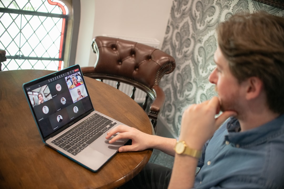 man on laptop participating in a video conference call remote team video meeting collaboration tools