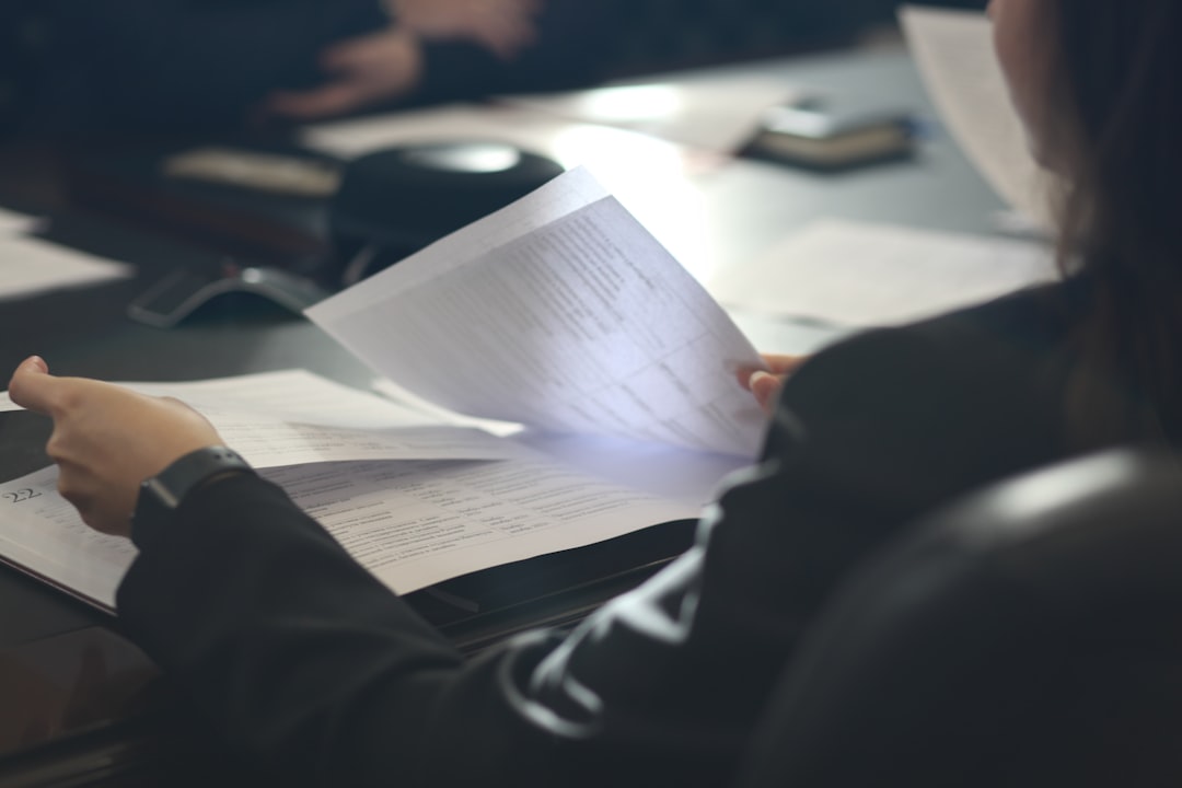 a woman sitting at a table reading a paper ocr document scanning invoice data finance team