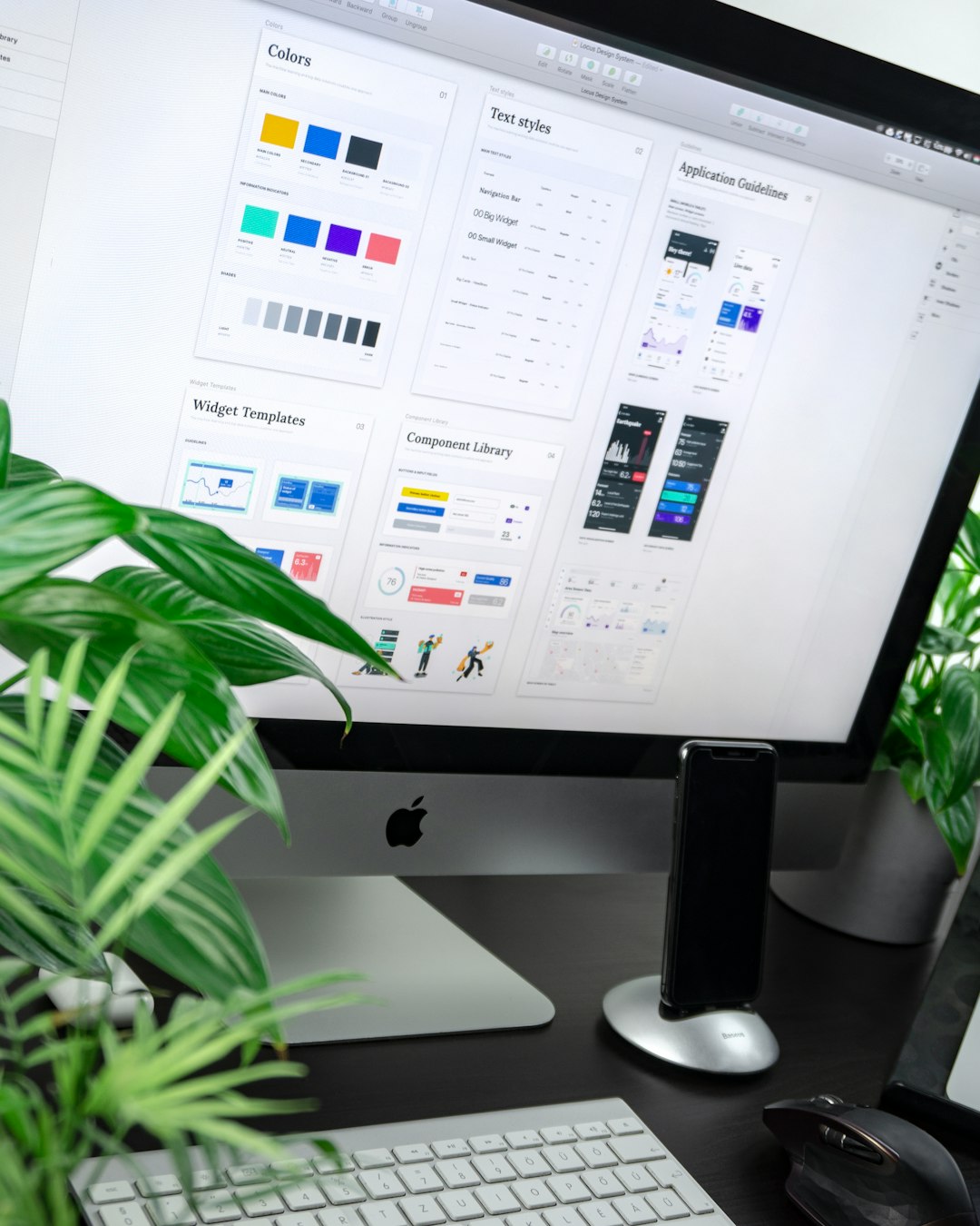 a computer monitor displaying a design system interface with plants on a desk web design team project planning client dashboard