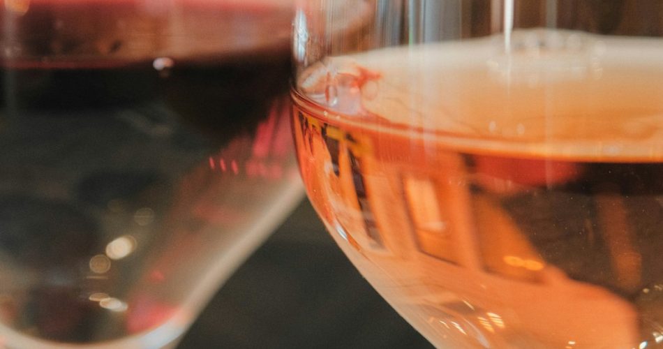 two glasses of wine one red one rose vineyard dining sunset wine glasses