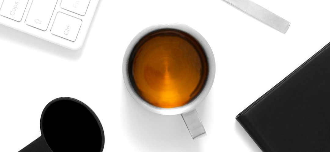 a cup of coffee and a cell phone on a table background removal product photo transparent png