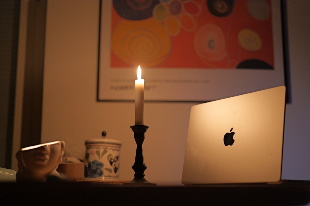 a laptop computer sitting on top of a wooden table macbook startup screen waveform audio editing creative workspace