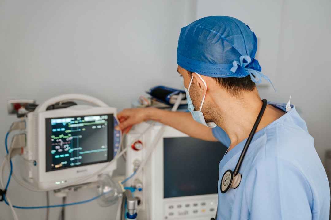 a man in scrubs and a stethoscope looking at a monitor medical translation workflow privacy security multilingual healthcare