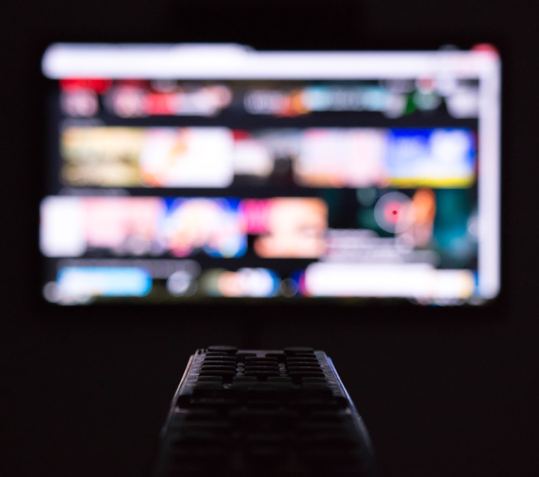 a remote control sitting in front of a television streaming app subscription settings television screen