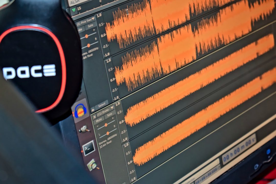 black and red headphones on black computer monitor audio waveform low latency digital interface