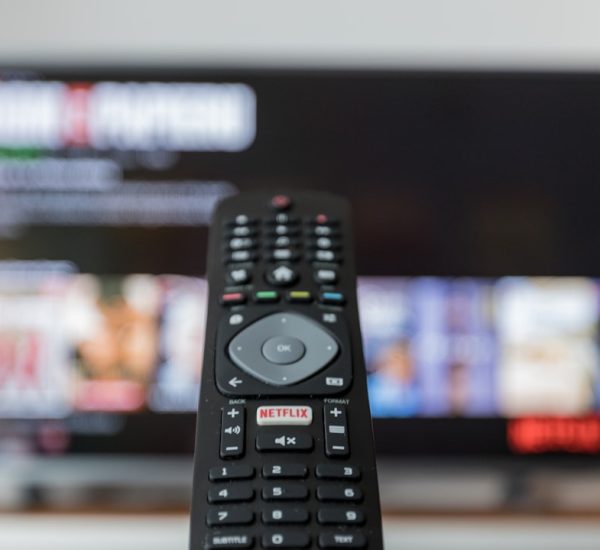 How to Find the IP Address of a Roku 4 black remote control on brown wooden table streaming app subscription settings television screen
