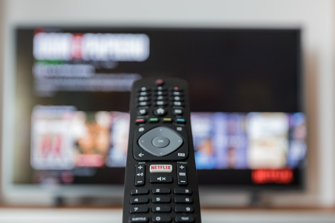 black remote control on brown wooden table streaming app subscription settings television screen