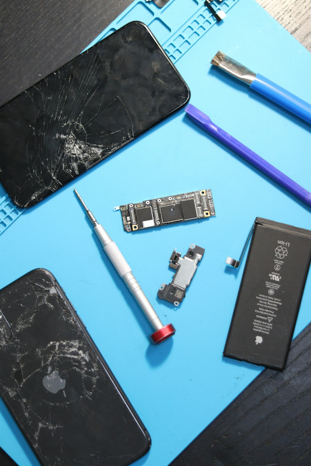 damaged iphones and repair tools are displayed phone repair battery replacement technician tools