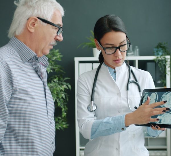 doctor shows medical scan to elderly patient doctor interpreter tablet patient communication hospital