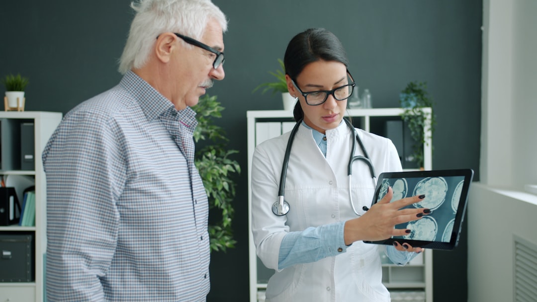 doctor shows medical scan to elderly patient doctor interpreter tablet patient communication hospital