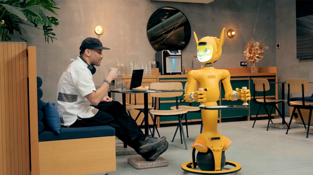 man in cafe interacts with a yellow robot human robot collaboration content creation happy workspace