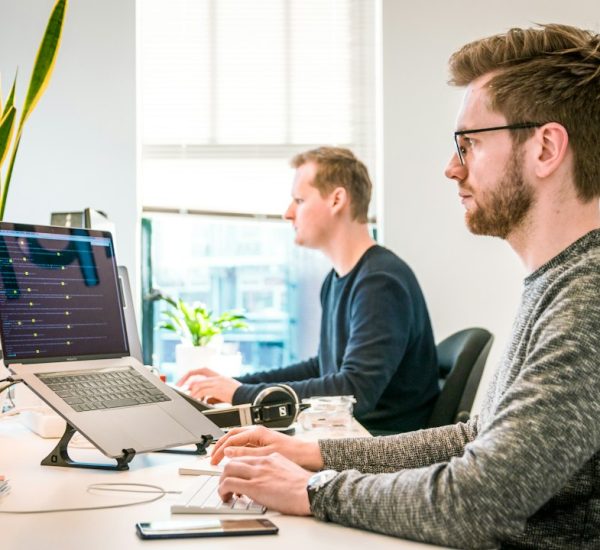 man sitting on chair wearing gray crew neck long sleeved shirt using apple magic keyboard agency team software developers project planning