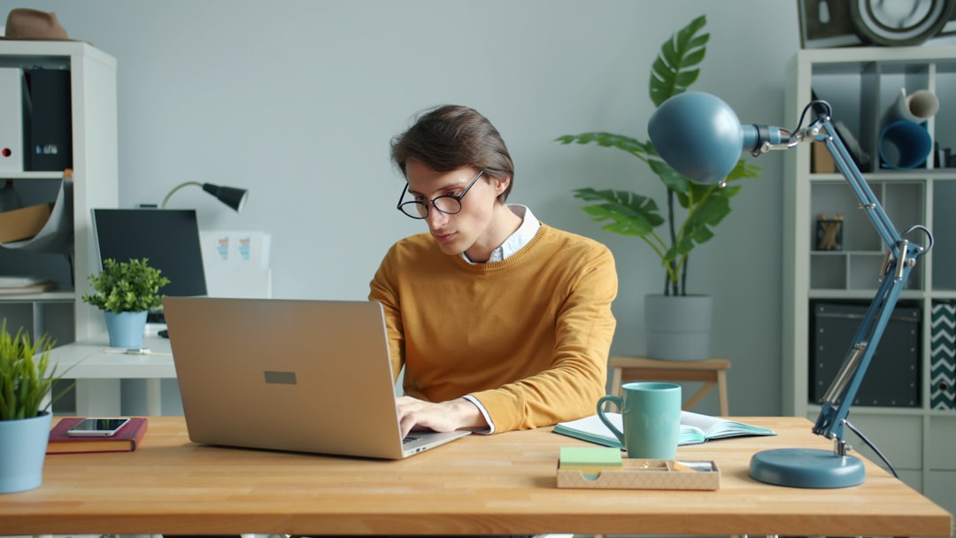 man working on laptop at a desk ai tools freelancer workspace online income 1