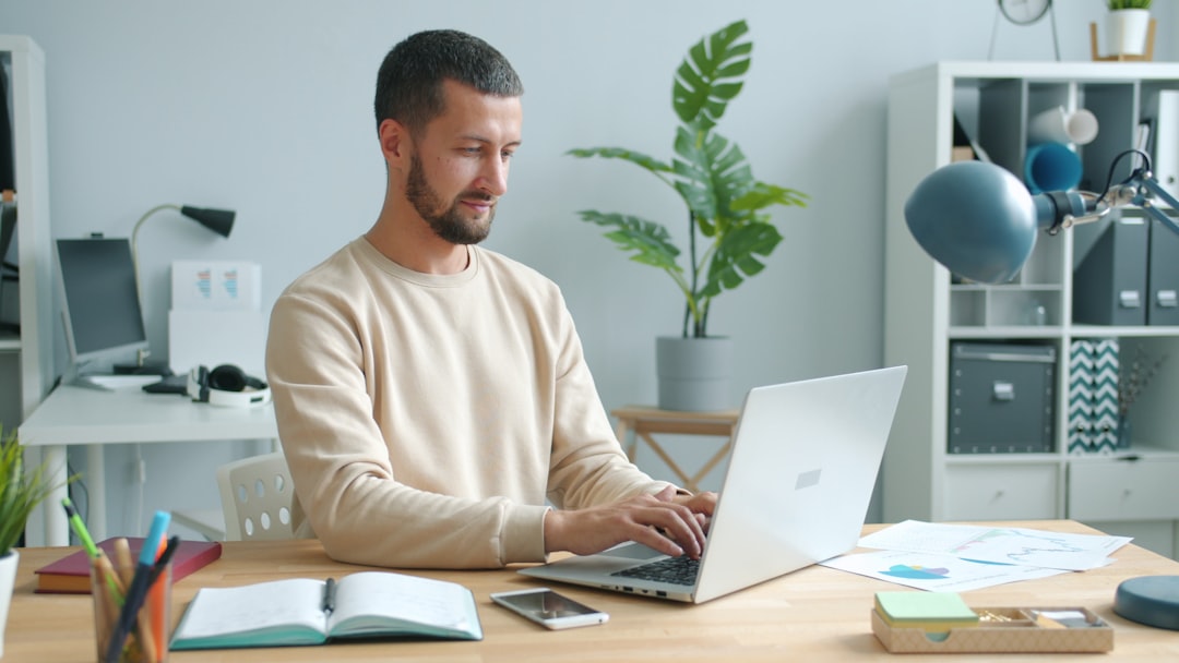 man working on laptop at a desk ai tools freelancer workspace online income