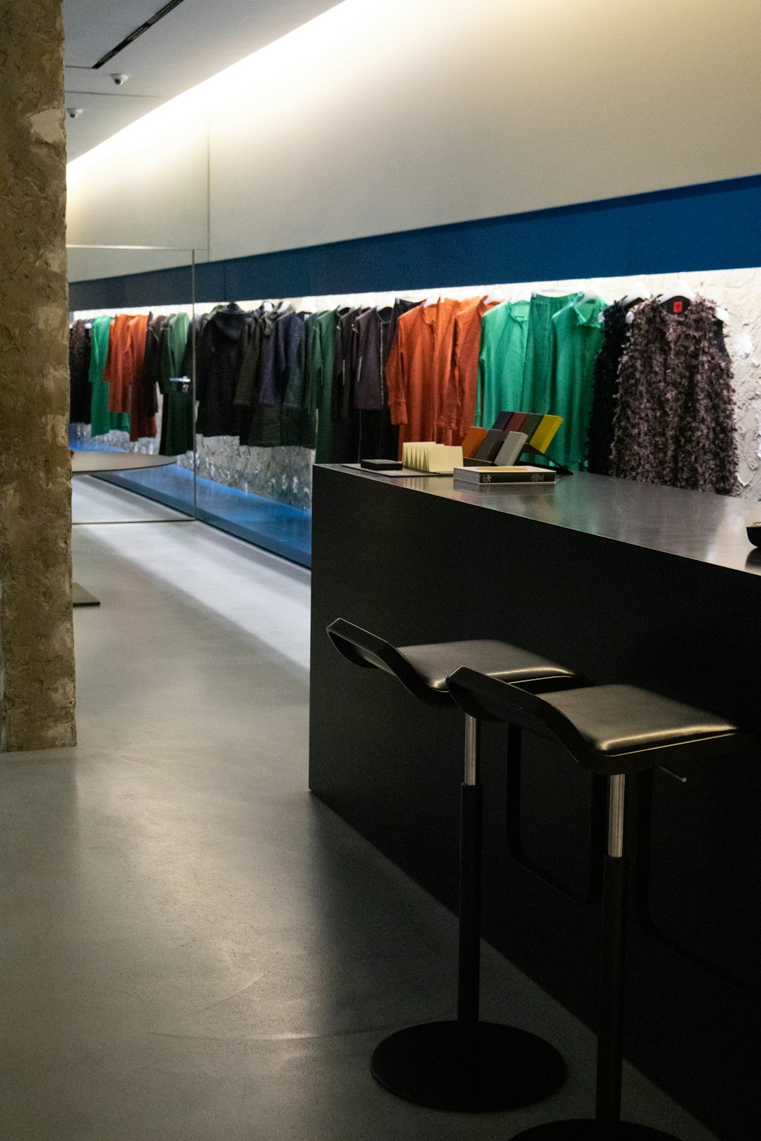 modern clothing store interior with colorful garments on display retail checkout handheld terminal boutique store customer payment