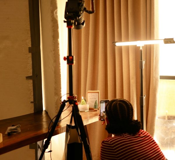person filming with camera on tripod indoors camera setup film student soft light indoor studio