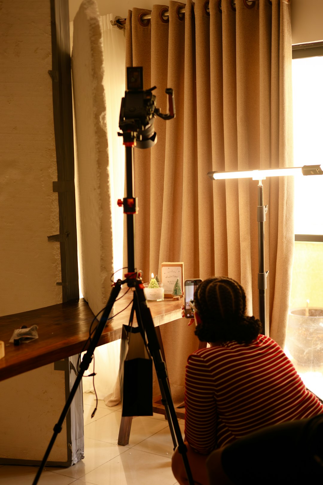 person filming with camera on tripod indoors camera setup film student soft light indoor studio