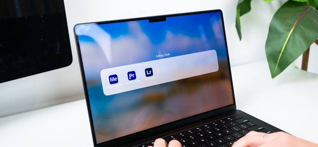 person typing on a laptop with software icons macbook startup screen waveform audio editing creative workspace