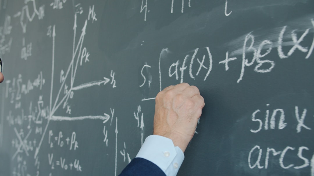 teacher writing mathematical formulas on a blackboard distributive property algebra steps teacher board