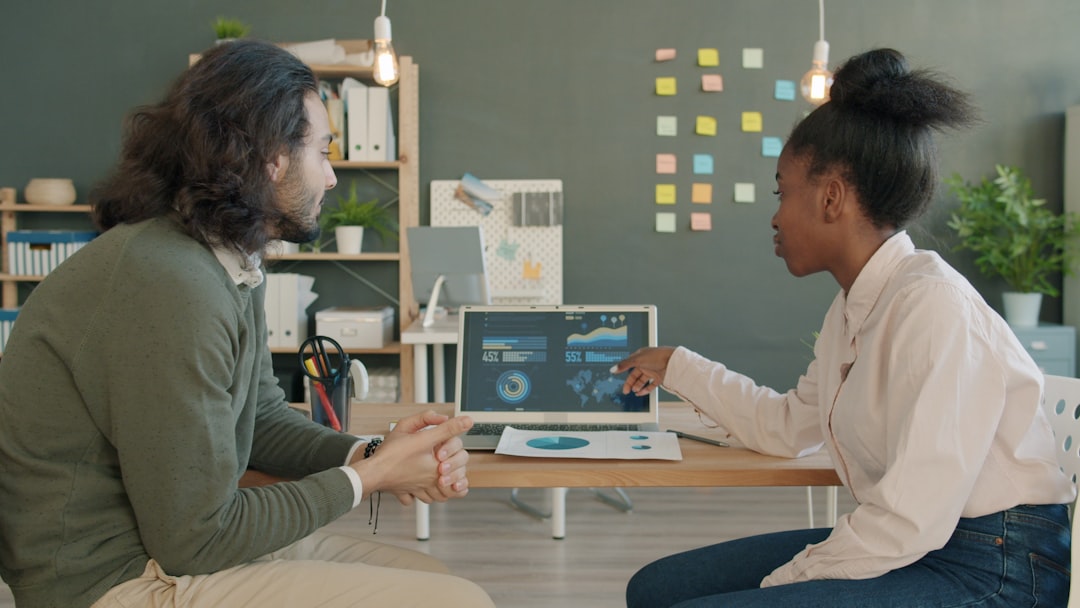 two colleagues discussing data on a laptop screen connected data digital transformation business growth analytics team