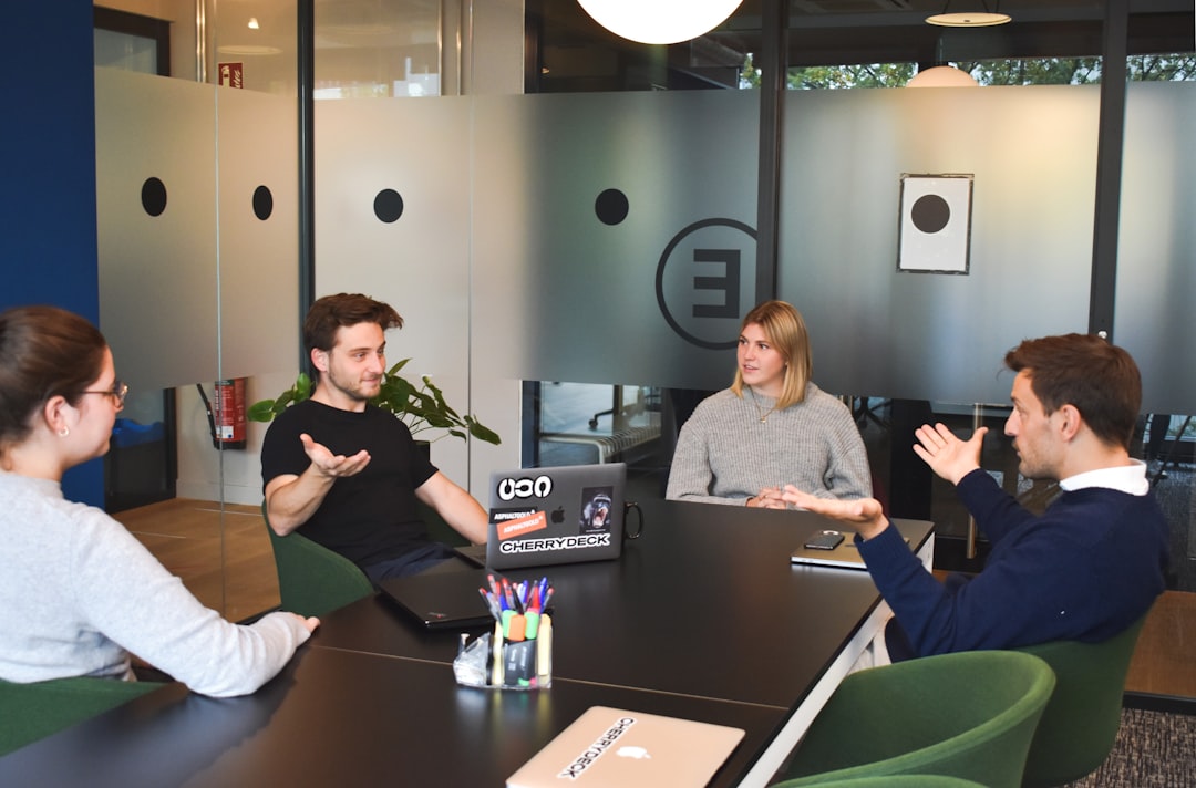 woman in black long sleeve shirt sitting beside woman in gray long sleeve shirt office team retention strategy marketing meeting