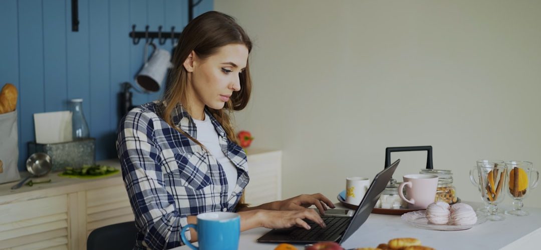 woman working on laptop in a bright kitchen ai tools freelancer workspace online income