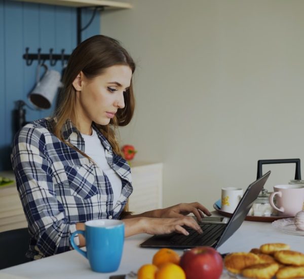 5 Best AI Tools to Make Money Online in 2026 8 woman working on laptop in a bright kitchen ai tools freelancer workspace online income