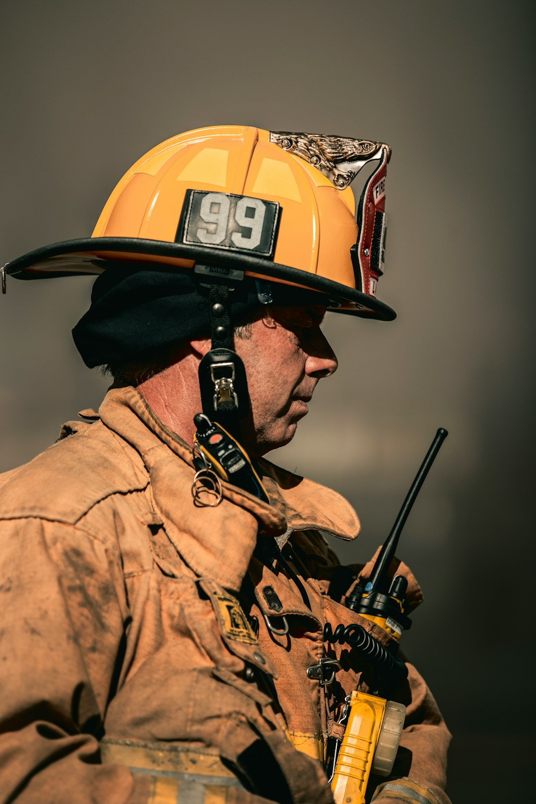 a fireman wearing a helmet and holding a radio emergency radios responders communication gear