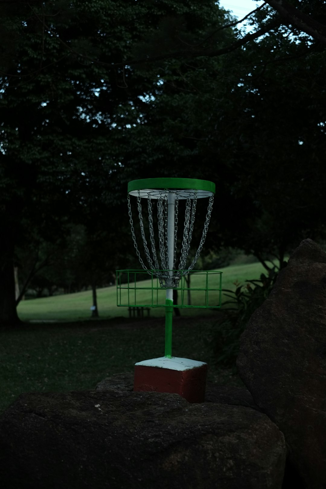 a green and white frisbee is in the air disc golf basket chains close putt tournament