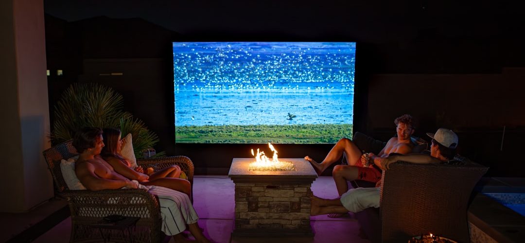 a group of people sitting around a fire pit home theater streaming apps movie night