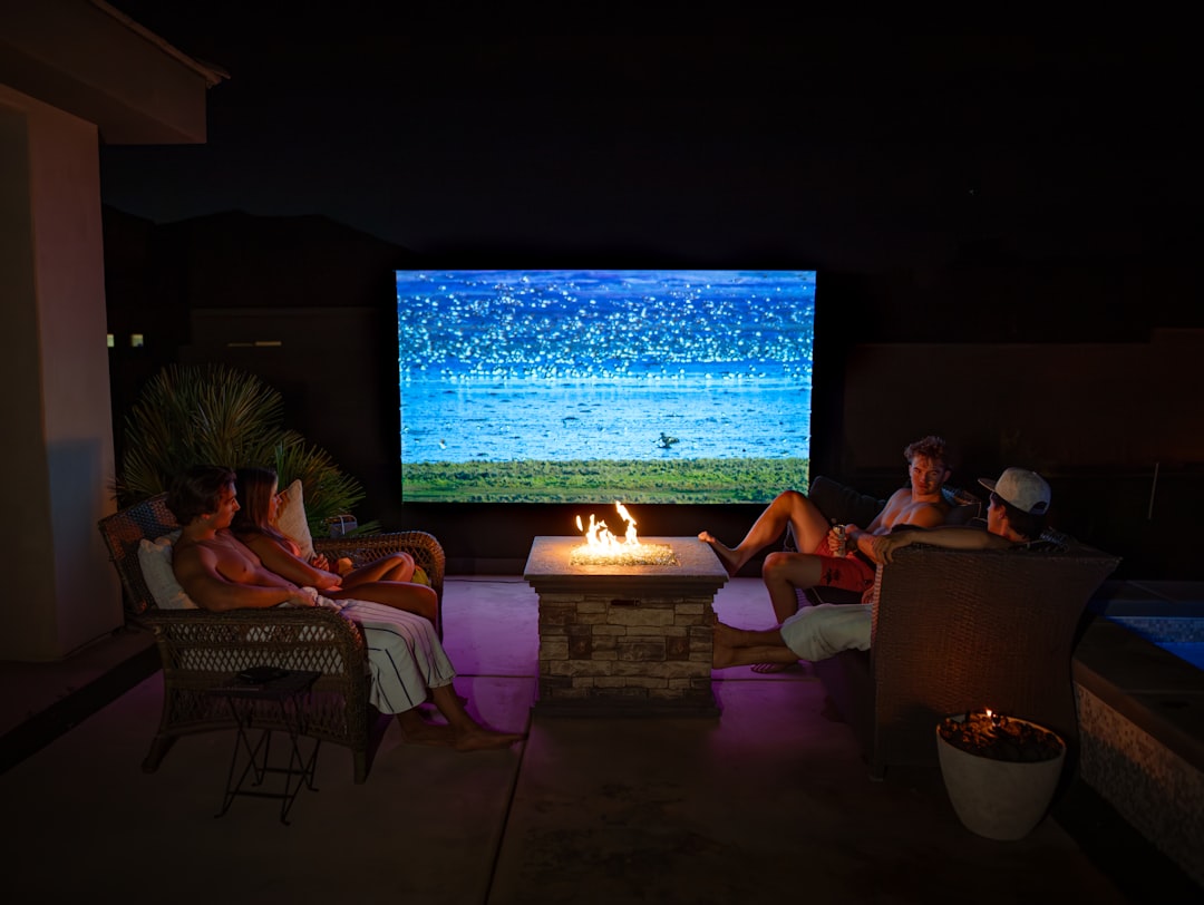 a group of people sitting around a fire pit home theater streaming apps movie night