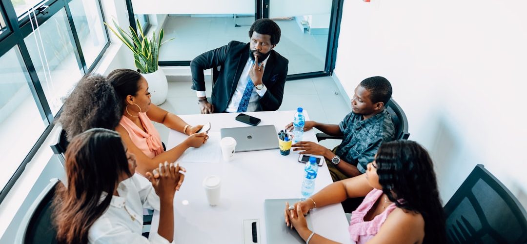 a group of people sitting around a white table business meeting strategy board team alignment objectives