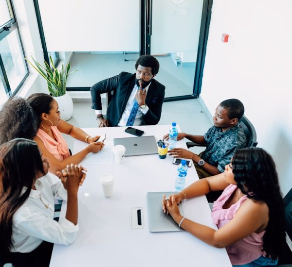 a group of people sitting around a white table business meeting strategy board team alignment objectives