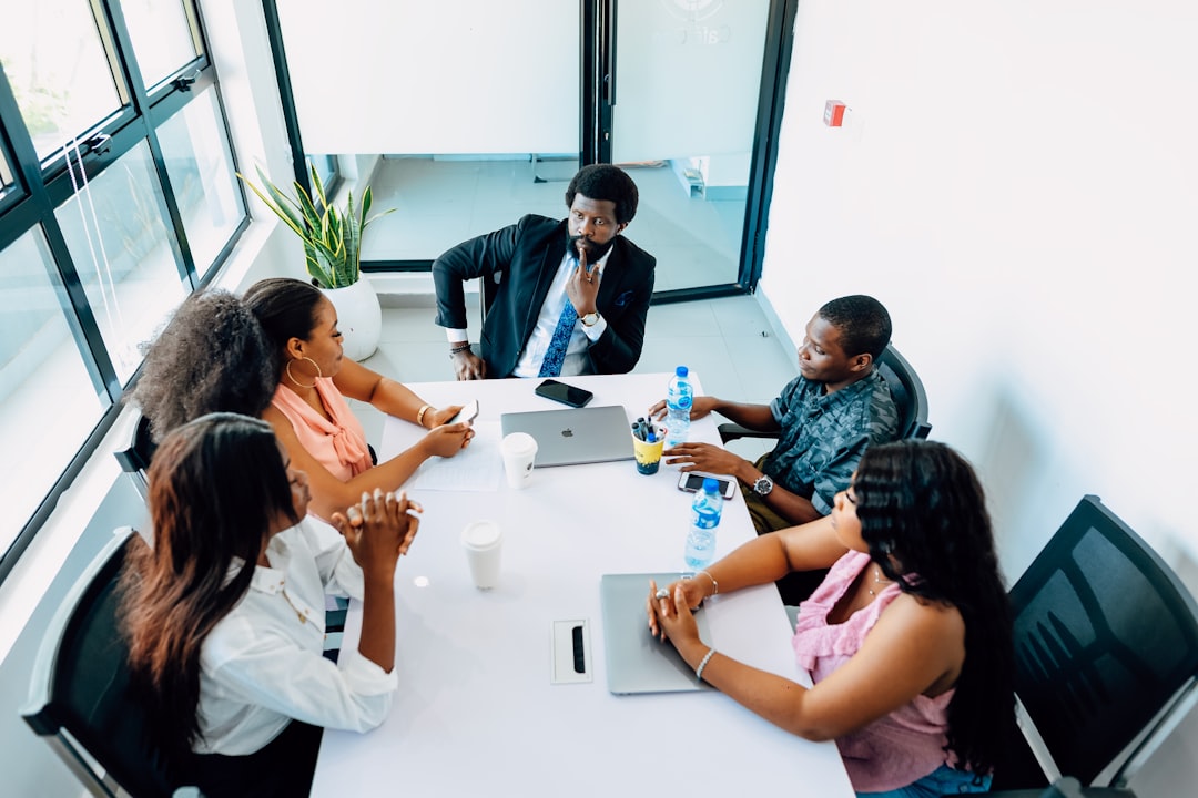 a group of people sitting around a white table business meeting strategy board team alignment objectives
