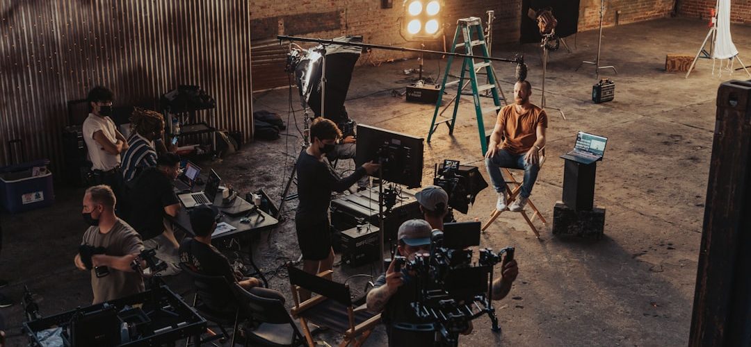 a group of people standing around a camera set up behind the scenes shoot creative team studio setup