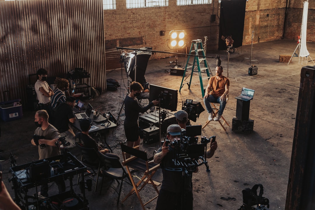 a group of people standing around a camera set up behind the scenes shoot creative team studio setup