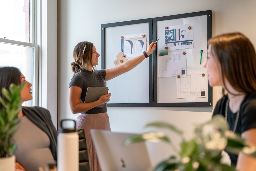 a group of women sitting around a table working on a project leadership discussion planning session progress charts collaboration
